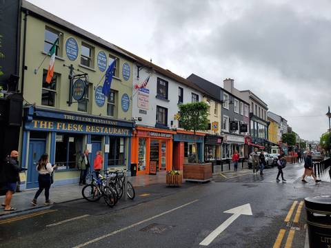 A row of colorful shops on a busy street.