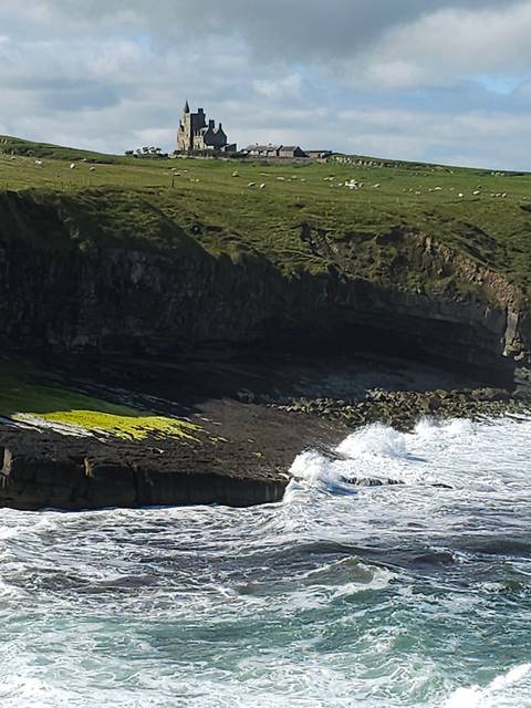       Coastal landscape with cliffs and ocean waves.
  