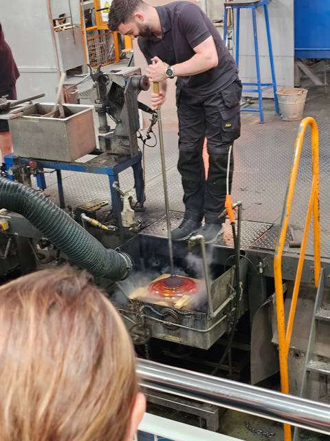 Glassmaking demonstration with a person shaping glass.