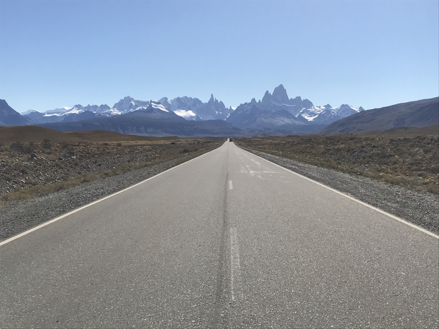 Wide open road leading towards distant mountains.