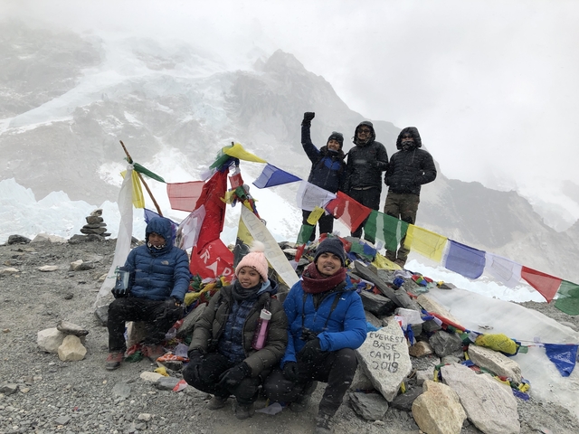 Group of people at a mountain base camp with flags.