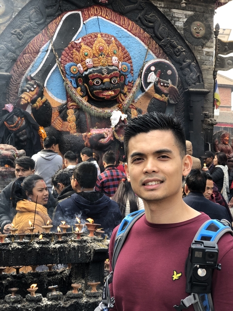 Crowded scene in front of a large Hindu statue.