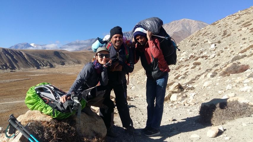 Three hikers posing in a mountainous landscape.