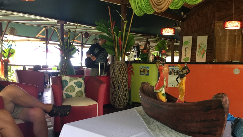       Colorful interior of a restaurant with art and guests.
  