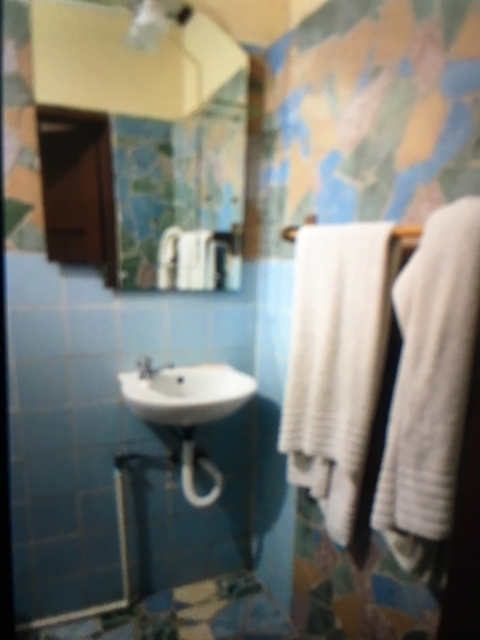       Blurry image of a bathroom with a sink and towels.
  