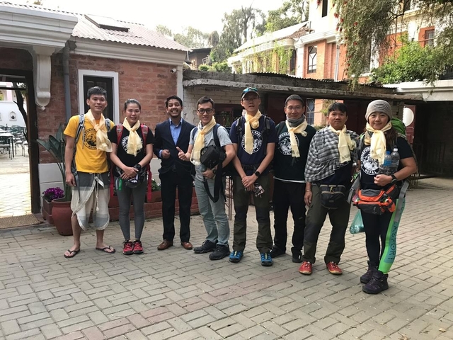 Group of trekkers with a guide posing in a courtyard.