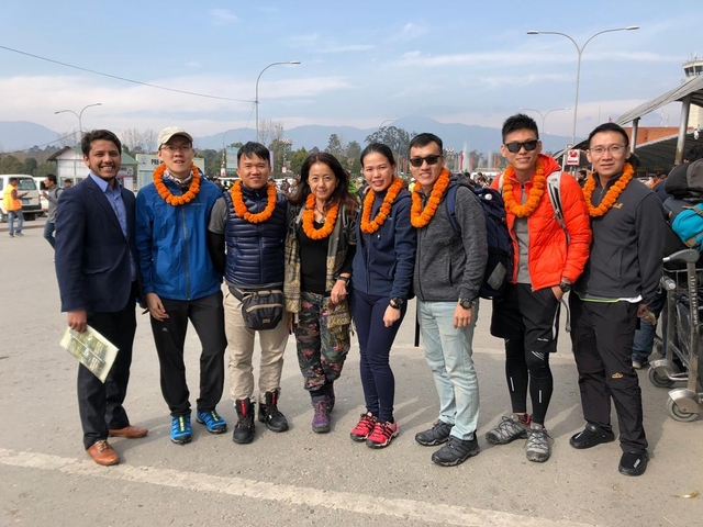 Group in garlands with mountains in the background.