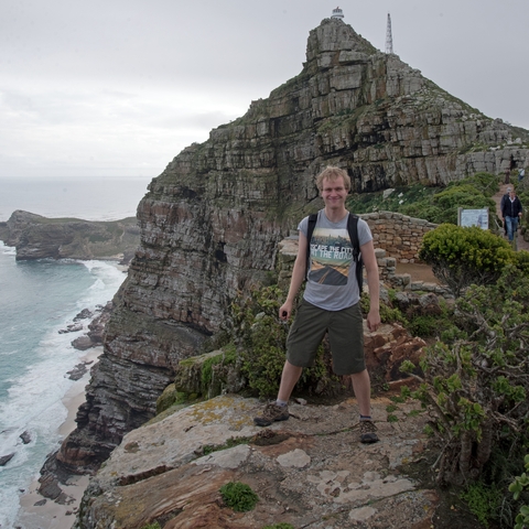       Person posing on a cliff with ocean view
  