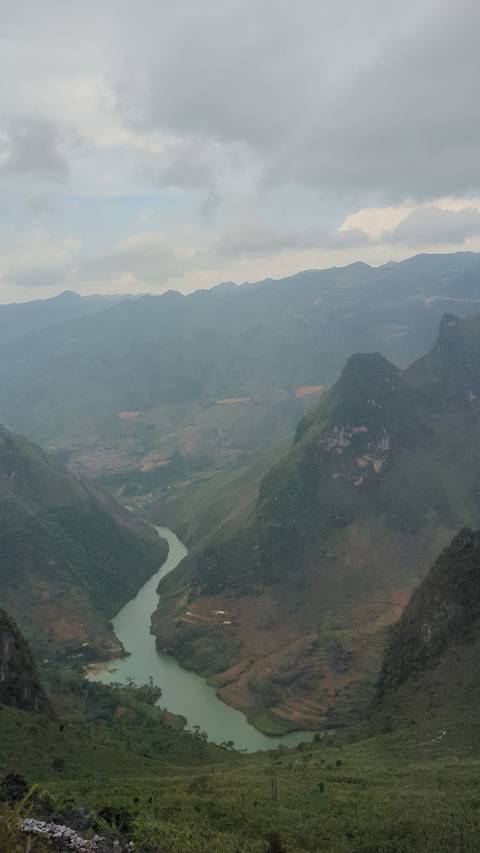 River in a mountainous landscape with overcast skies.