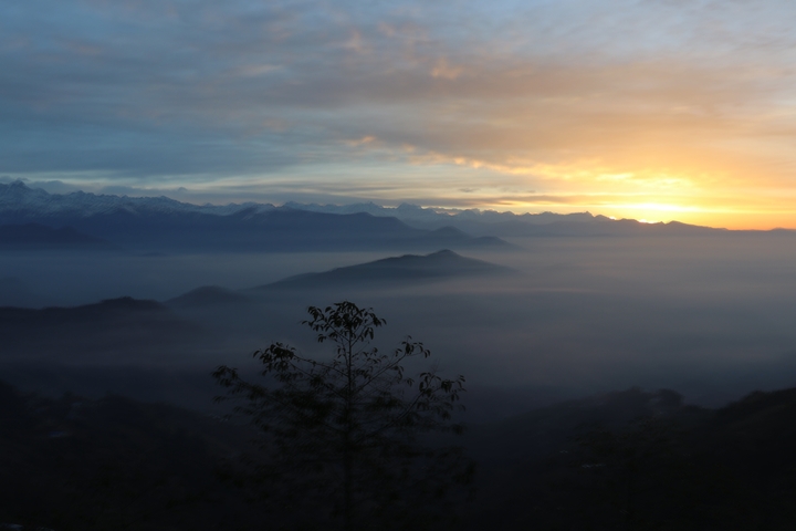       Sunrise over misty mountains with colorful sky.
  