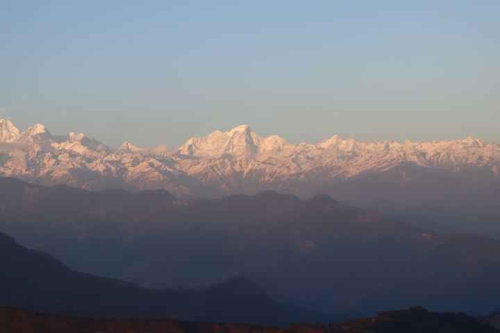       Mountain range with sunlit peaks and shadows.
  