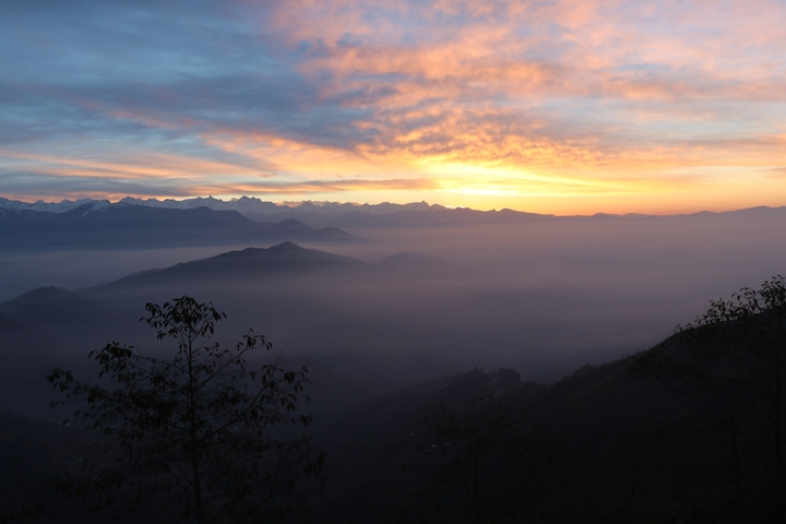       Vivid sunrise over mountain ranges and mist.
  