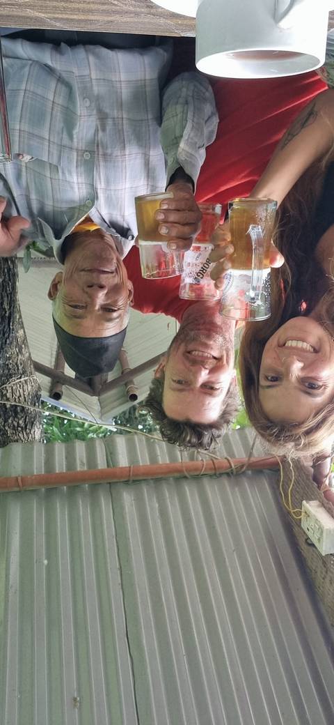 Group of people holding drinks inside a local establishment.