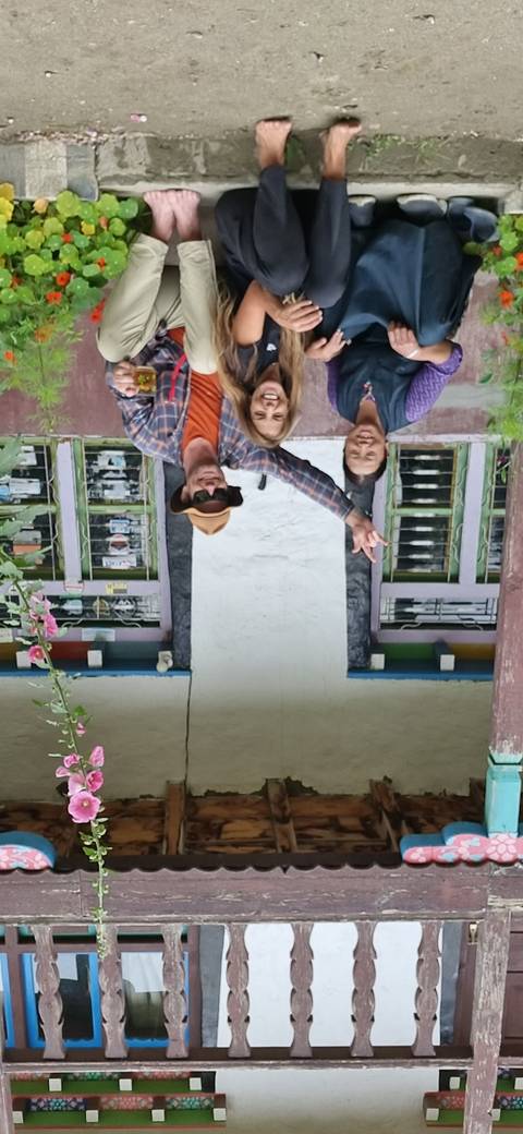 Three people sitting in front of a traditional building.