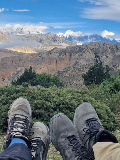       View of mountains with feet in the foreground.
  