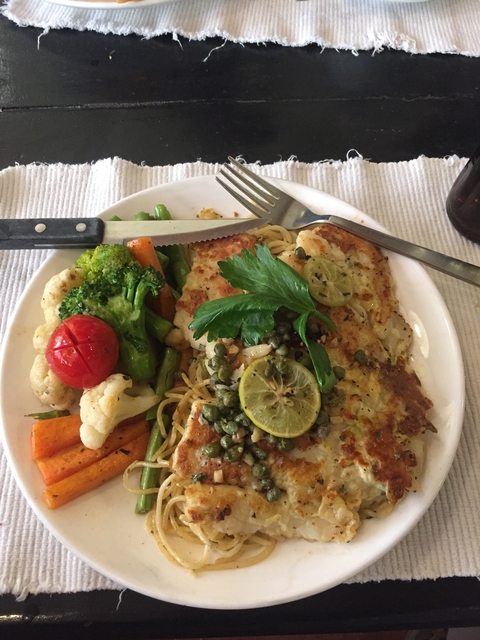       A plate of food with vegetables and a lemon garnish.
  
