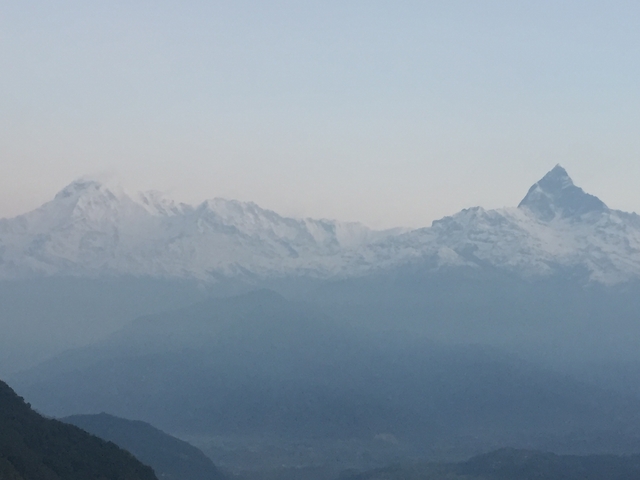       A distant view of snow-capped mountains under a clear sky.
  