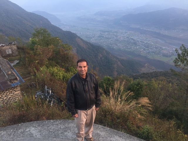       A person standing on a hill overlooking a valley.
  