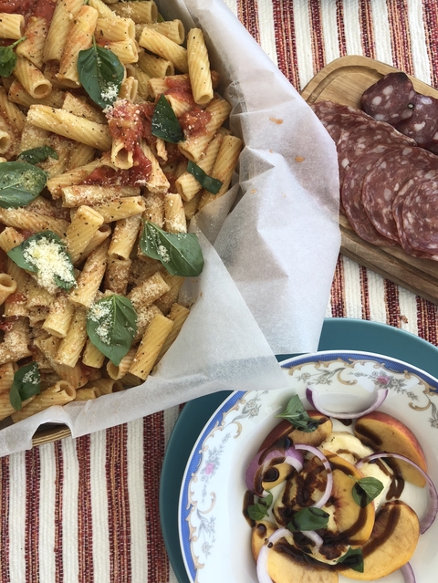       Close-up of a dish with pasta garnished with basil and cheese.
  