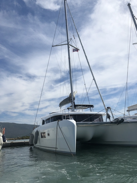      A sailboat against a cloudy sky.
  