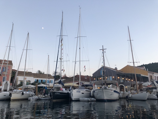       Sailboats docked in a marina during twilight.
  