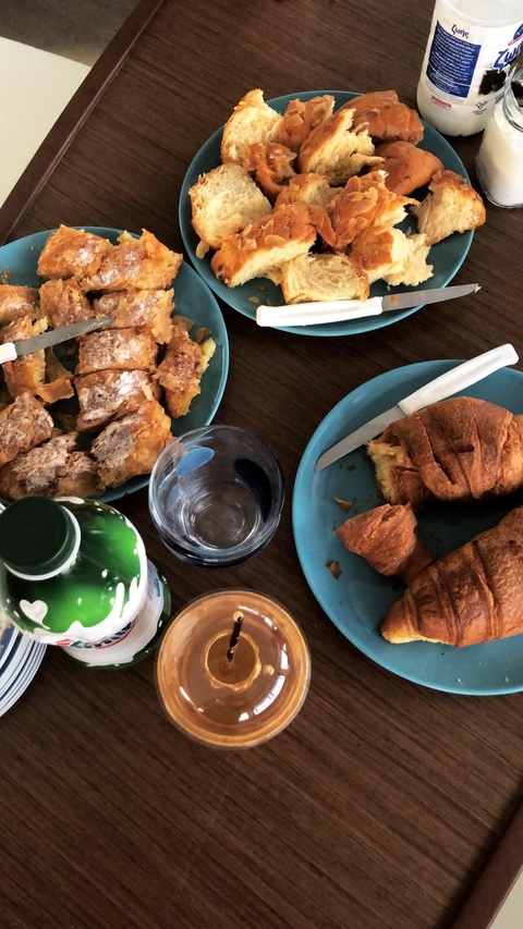      A table with pastries and drinks for breakfast.
  