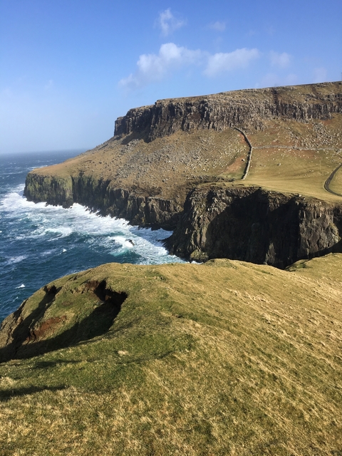 A scenic vista of a rocky coastline with waves.