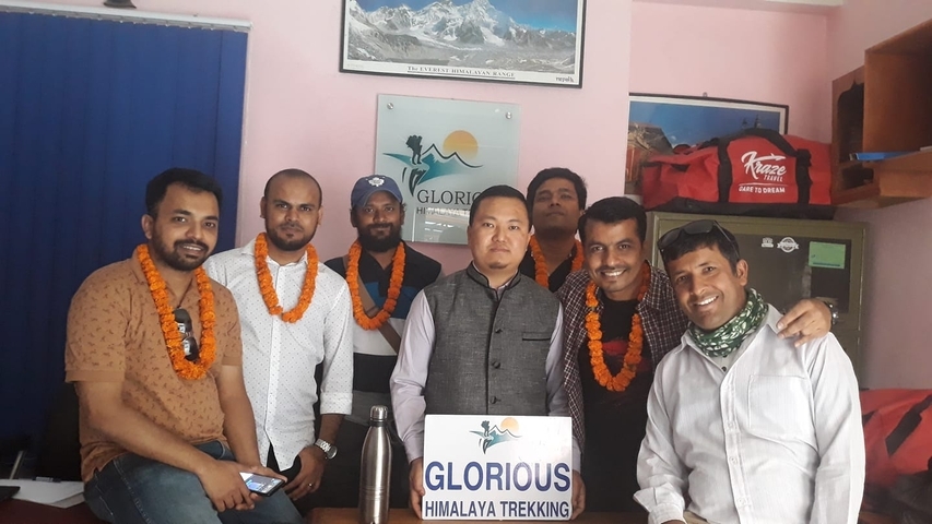       Group of people posing indoors with trekking gear.
  