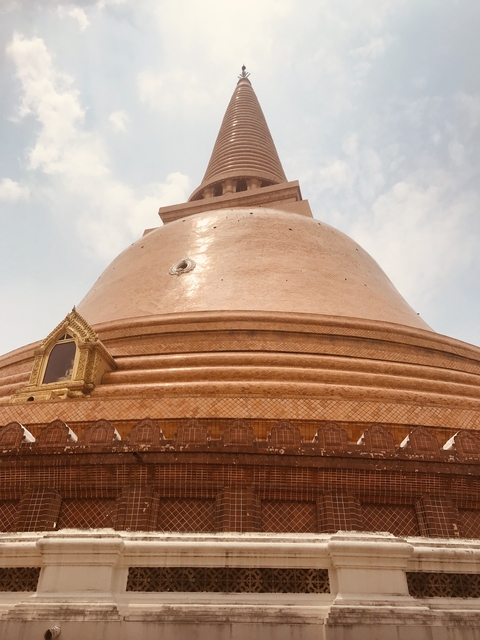 Large circular structure with intricate design under a blue sky.