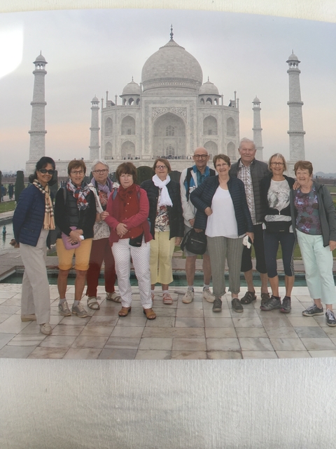 Group of tourists posing in front of a famous monument.