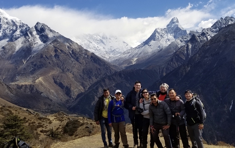 Group of hikers with snowy mountains in view.