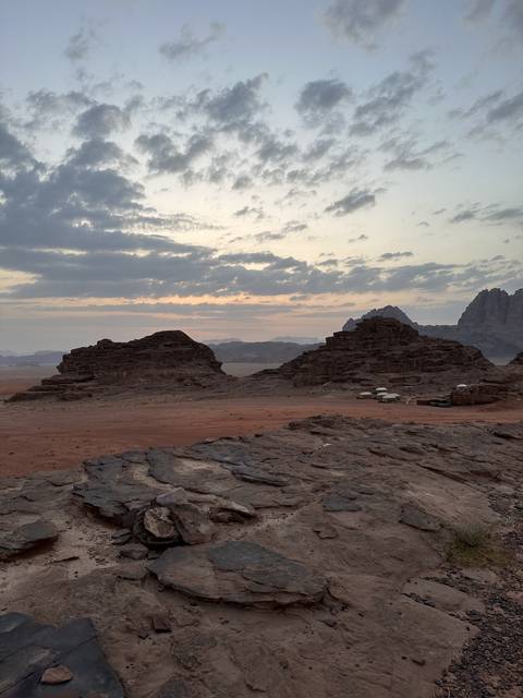       Desert landscape at dusk with cloudy sky.
  