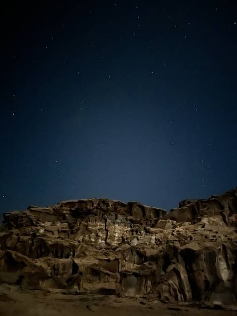Night sky with stars and rock formation.