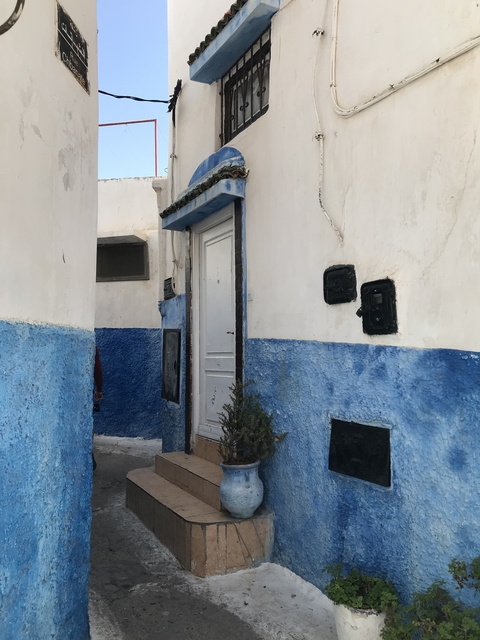       Narrow street with two-toned blue and white walls.
  