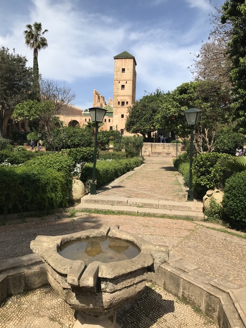 Beautiful garden path with lamp posts leading to an ornate structure.