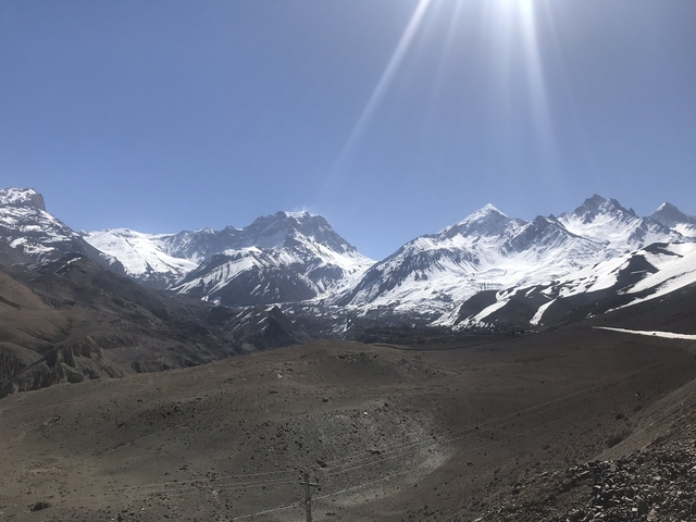 Panoramic view of snow-covered peaks against a blue sky.