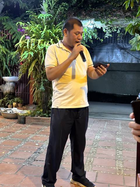       Person speaking on a microphone outdoors at night.
  