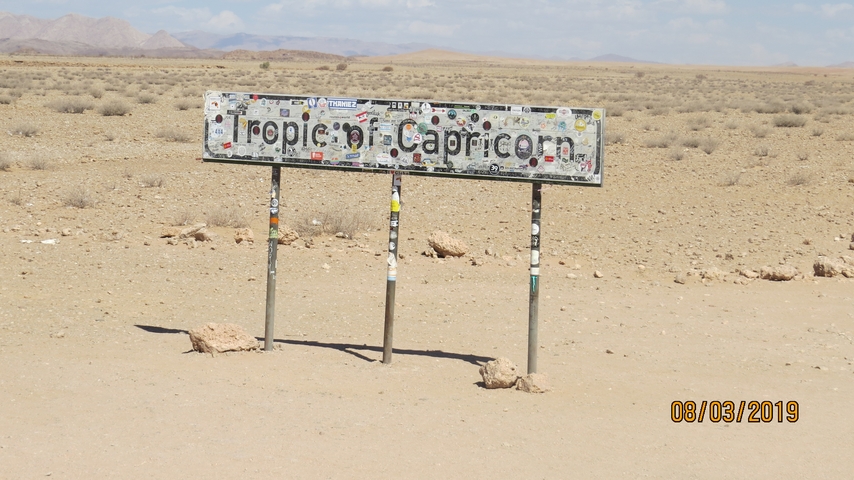       Sign for Tropic of Capricorn in a desert landscape.
  