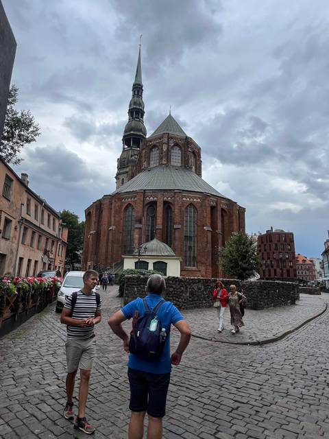 Historical building with people walking in the foreground, Riga, Latvia.
