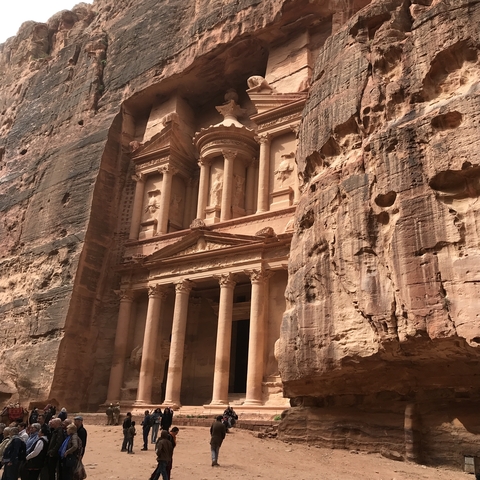 Ancient stone facade with columns carved into a canyon.