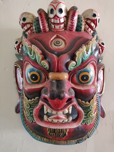       Close-up of a colorful and detailed mask sculpture.
  