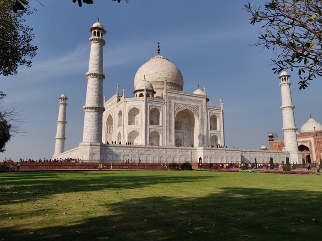       The Taj Mahal with tourists enjoying the view.
  