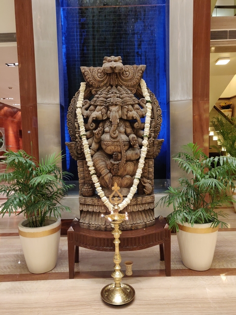 A detailed sculpture of a deity decorated with flower garlands.