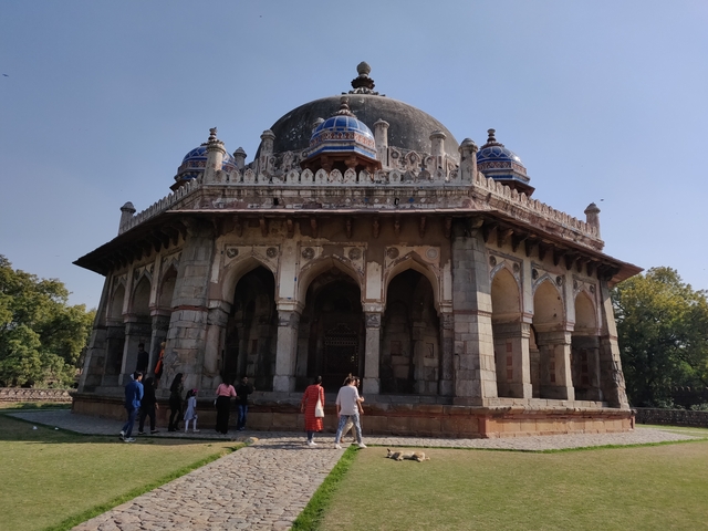       Tourists visiting a dome-shaped historical structure.
  