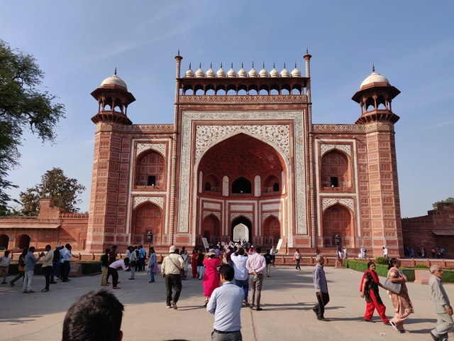       Visitors entering a grand decorative gateway.
  