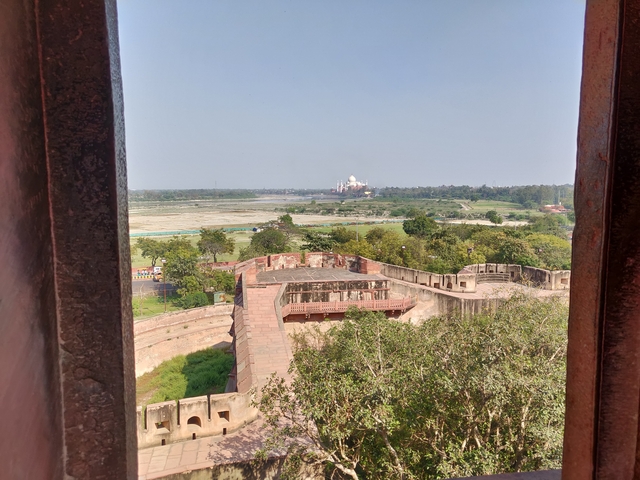       A distant view of the Taj Mahal from a historical site.
  