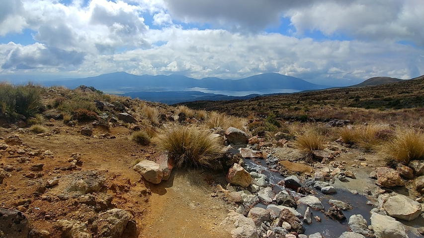 Landscape with rocks, grass, and distant mountains.