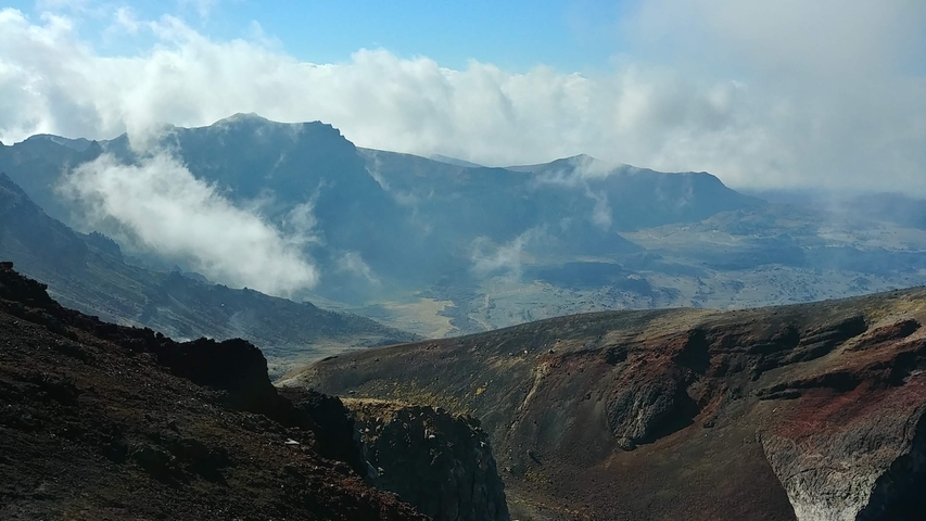Mountainous landscape with dramatic clouds and clear sky.