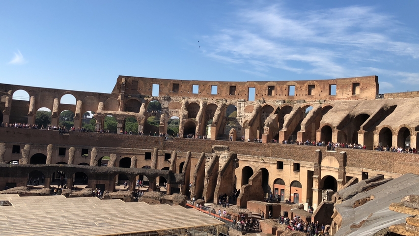       Interior view of the Colosseum in Rome with tourists.
  