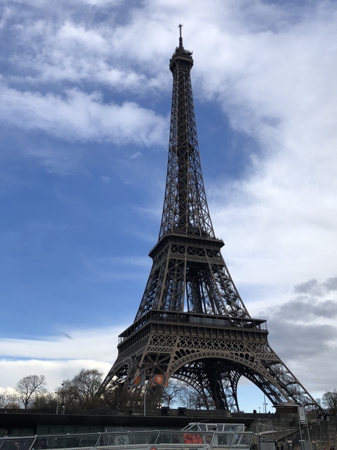       View of the Eiffel Tower under a cloudy sky.
  